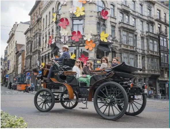  Turistas paseando por Bruselas en uno de los carruajes el&eacute;ctricos sin caballos. | VIVA 