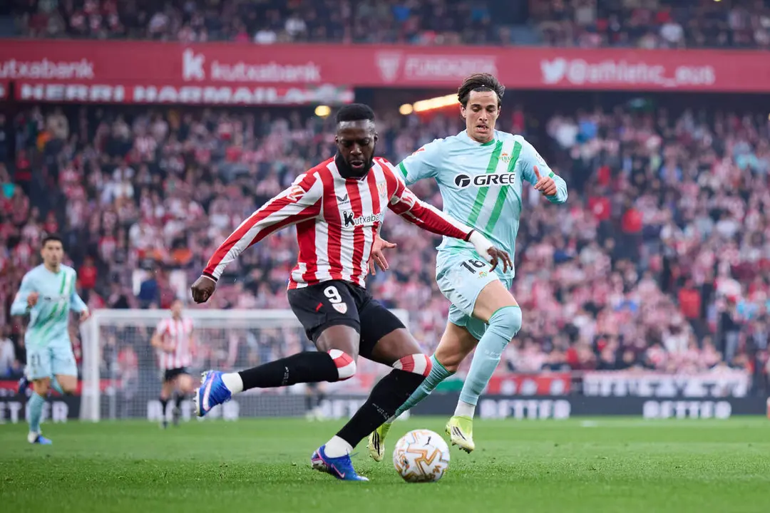  I&ntilde;aki Williams conduce el bal&oacute;n perseguido por Valent&iacute;n G&oacute;mez. | Ricardo Larreina/EP 