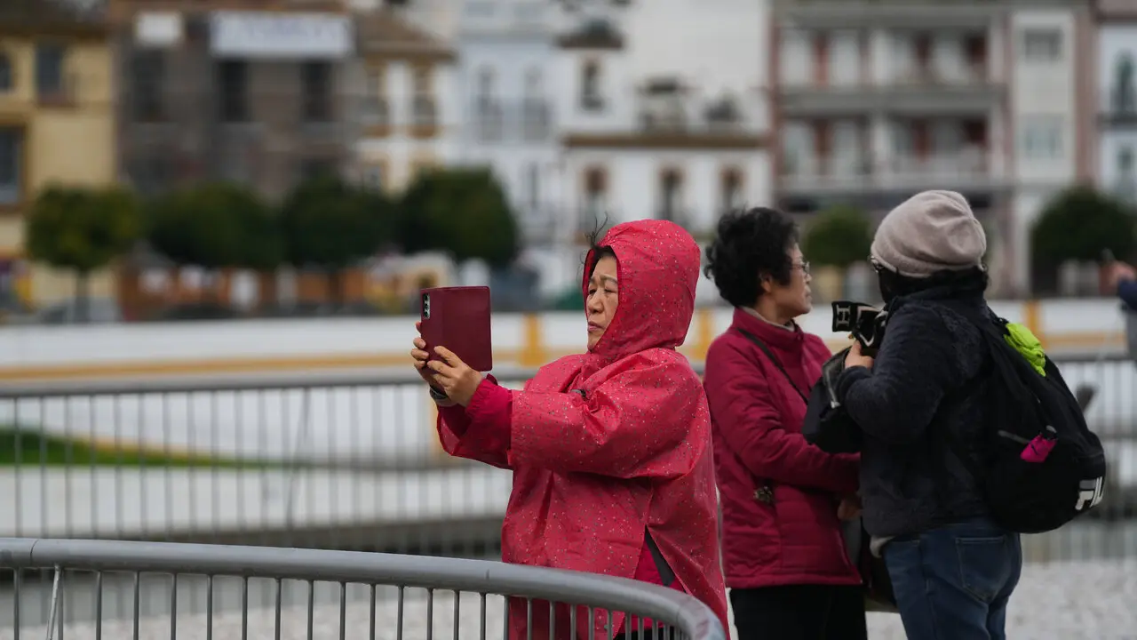  Turistas en Sevilla en plena borrasca. | EP 